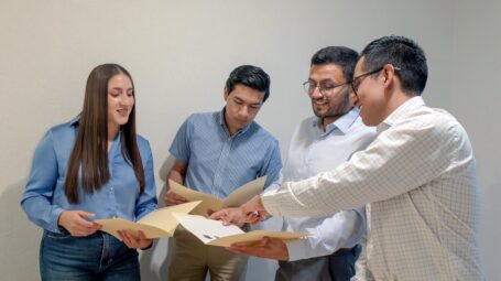 A Group of people looking at papers in the office during working hours